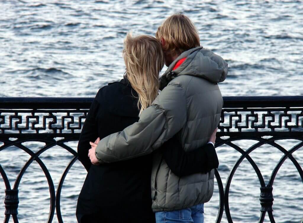 Lovely sweethearts hugging by the sea