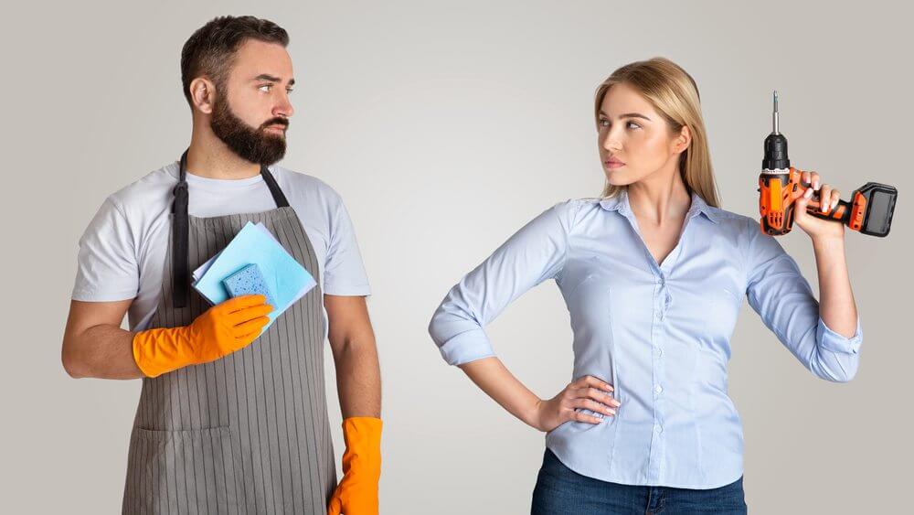 man wearing apron standing with wife holding a power drill