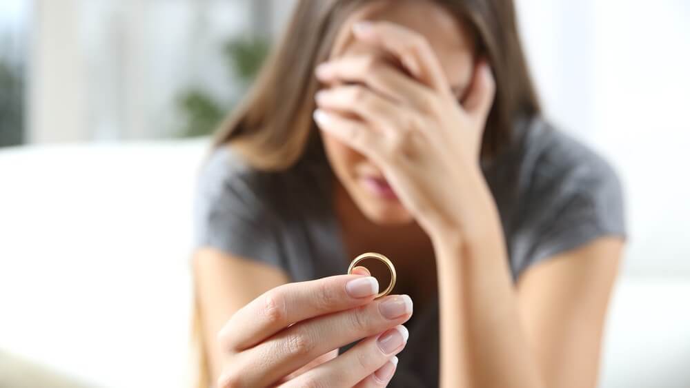 woman crying holding her ring with hand covering her face