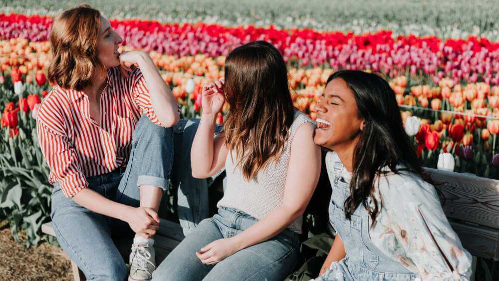 three female friends sitting and laughing together