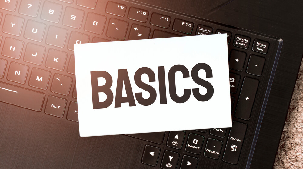 word BASICS written on a white paper placed on a laptop keyboard