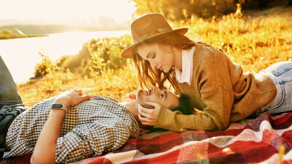 couple having a romantic time lying by the river