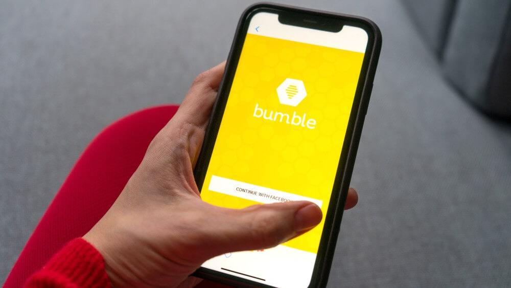 female hand holding a smartphone with Bumble on the screen