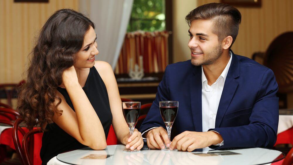 elegant young couple having drinking wine on a date