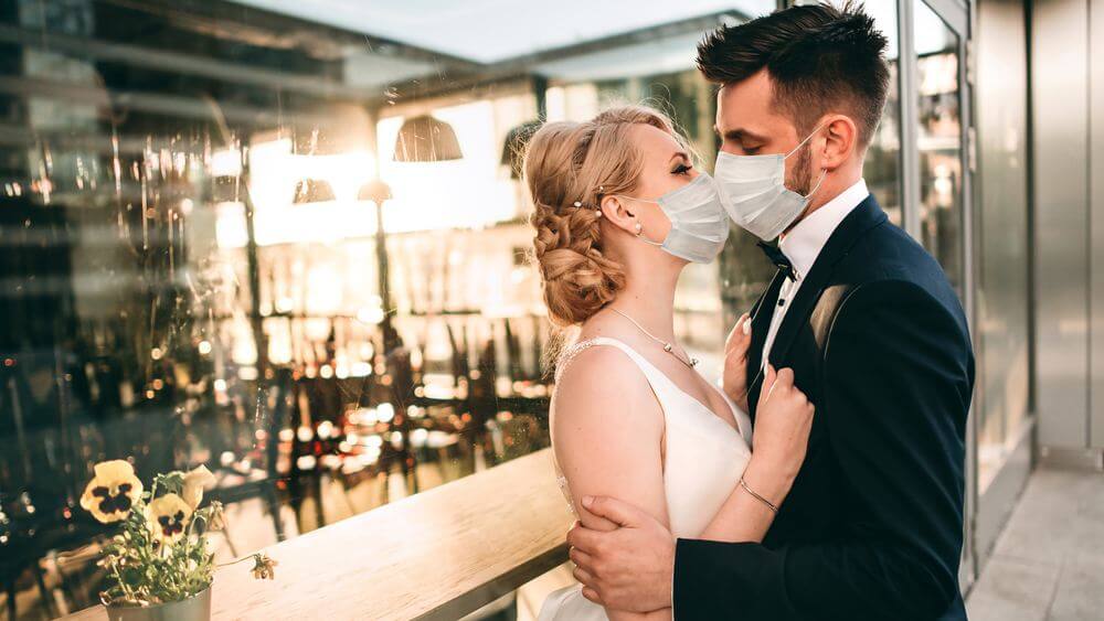 newlyweds kissing with masks on