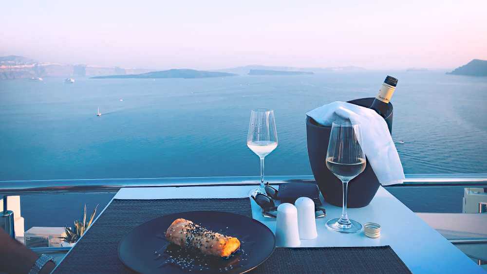 romantic dinner setting on a sea view with wine glasses