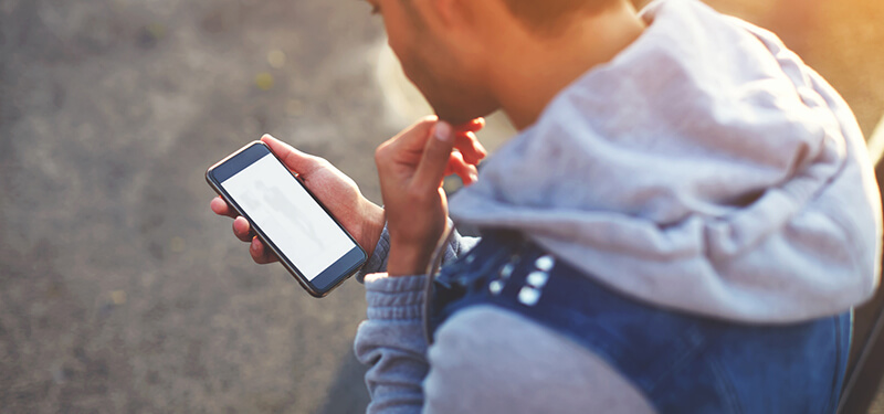 Man using phone while standing outdoors