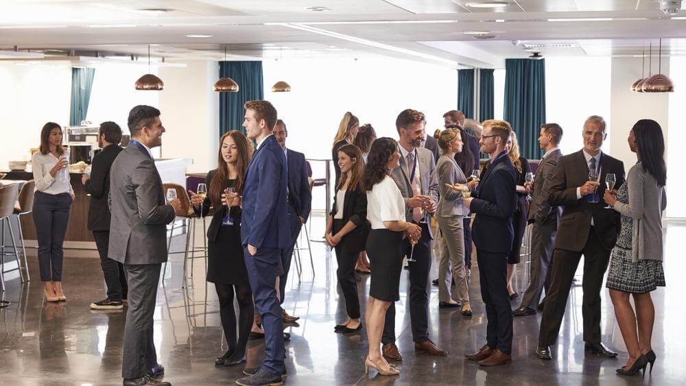 A group of business professionals networking in a large hall