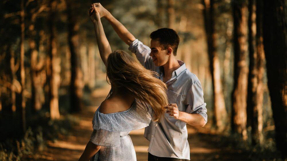 young couple dancing in a nature park