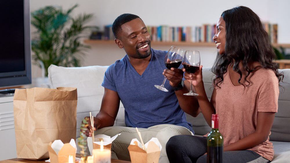 Couple enjoying wine and takeout