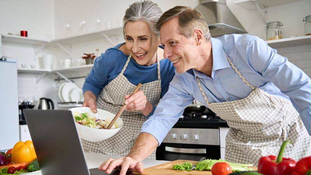 senior couple having a home cook class on their anniversary