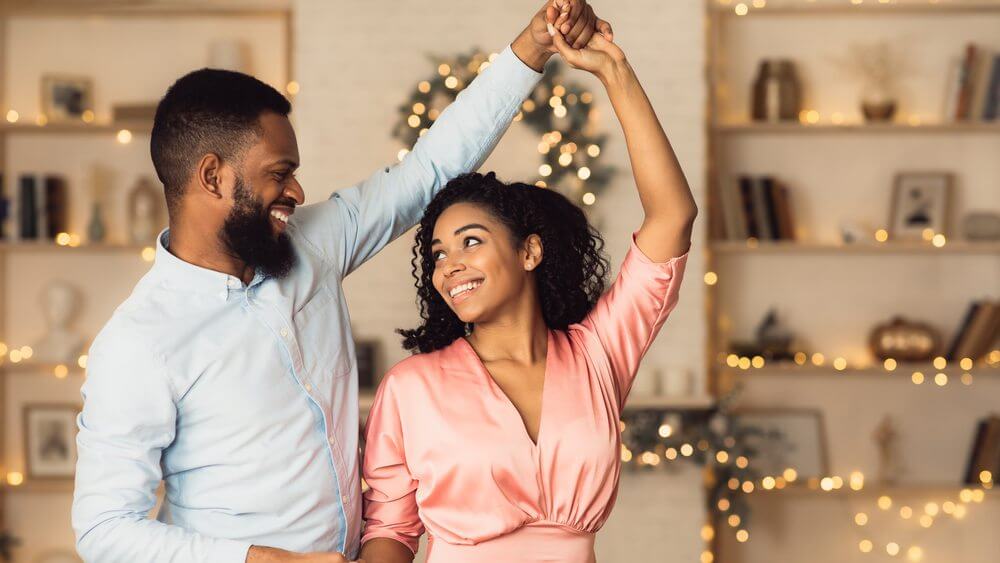 happy African American young couple dancing at home