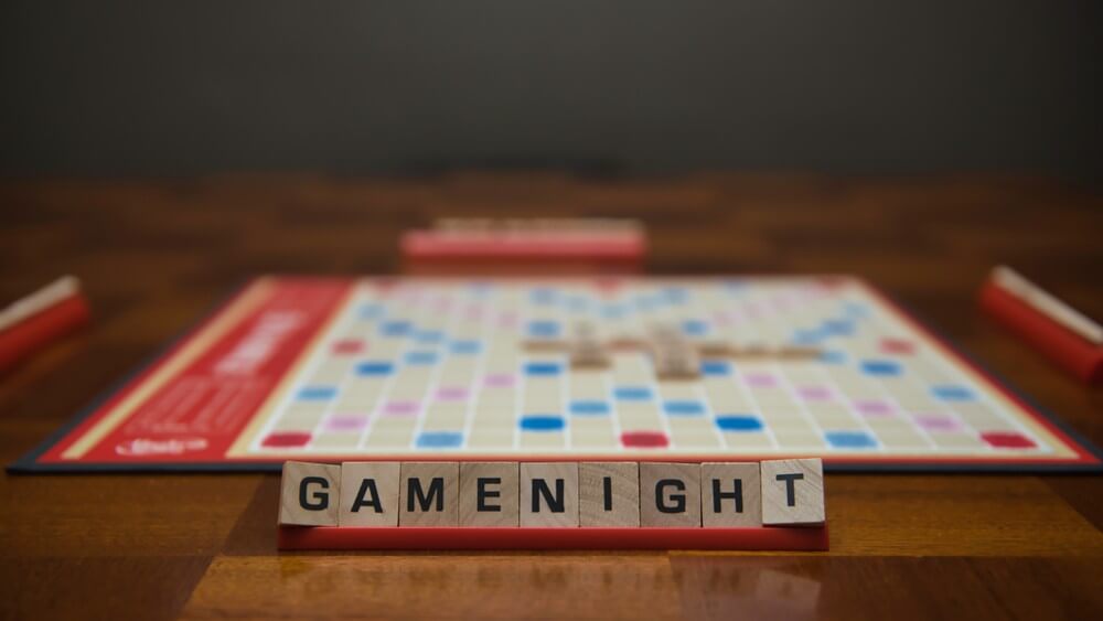 Word "gamenight" arranged on a scrabble tile rack