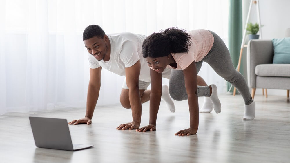 African American couple enjoying home workout on a laptop